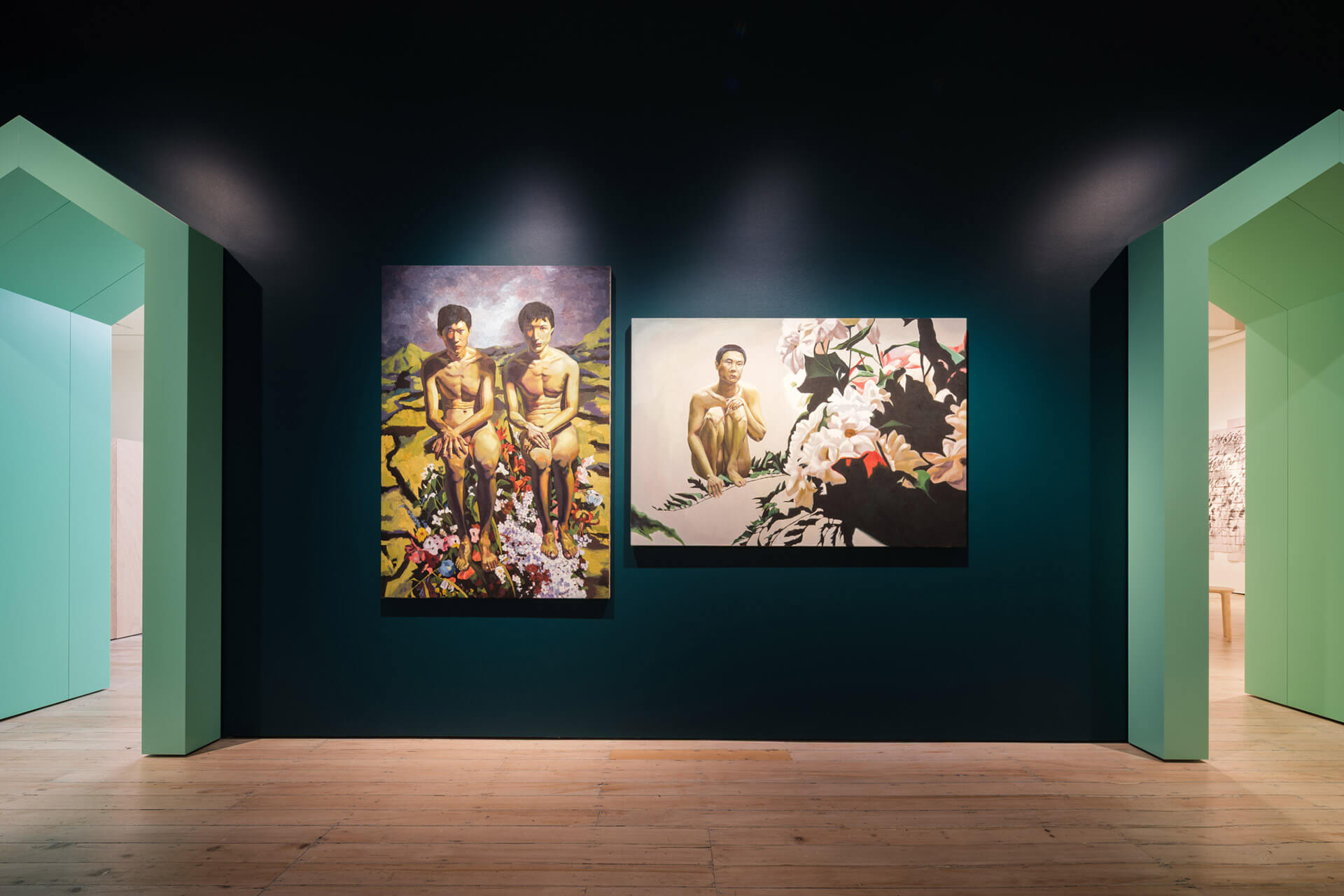 Two large contemporary paintings by Qi Wenzhang on dark teal wall showing figurative scenes with male subjects
