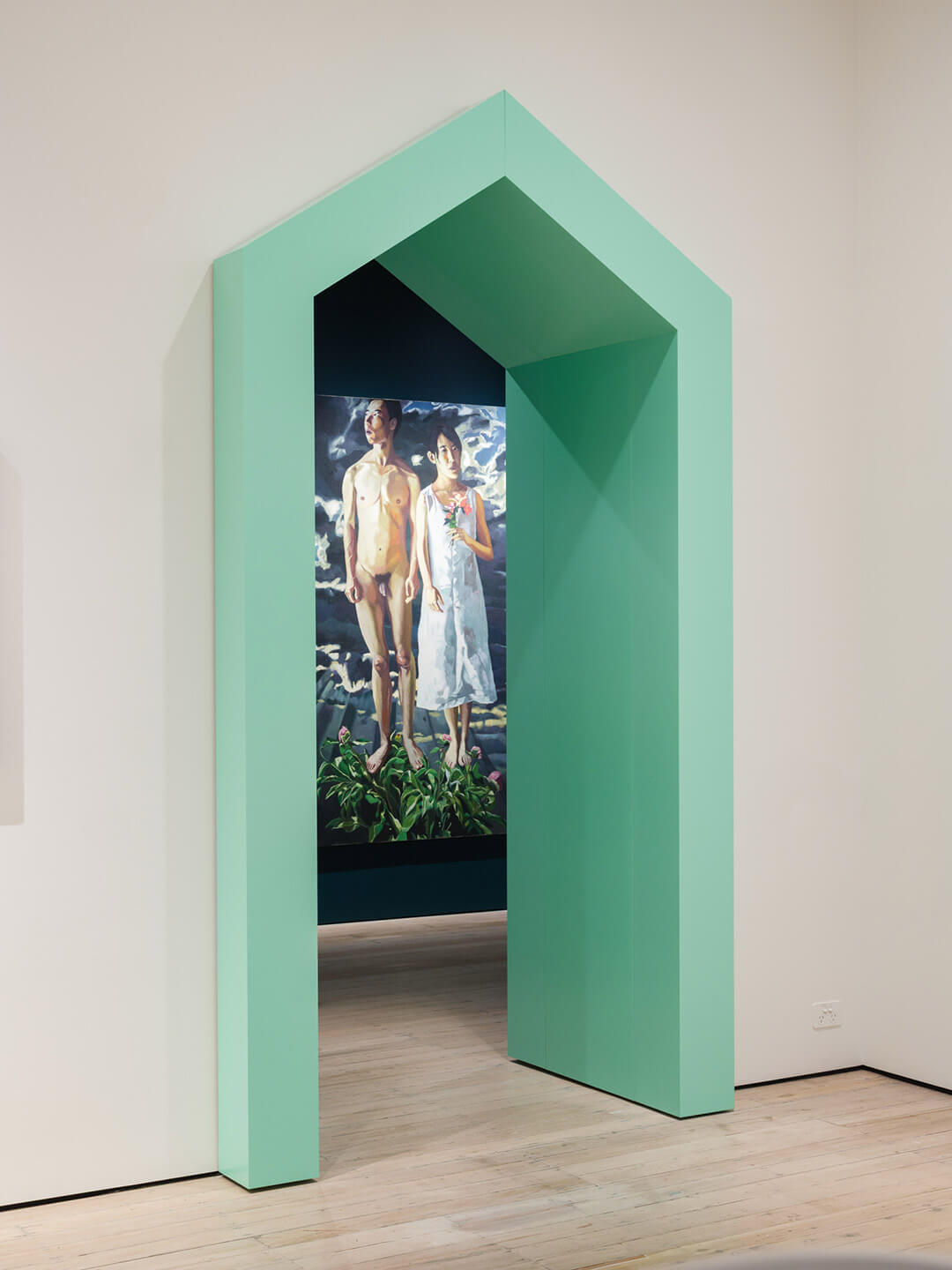 Gallery doorway view by Qi Wenzhang showing green architectural frame with his paintings visible in background space