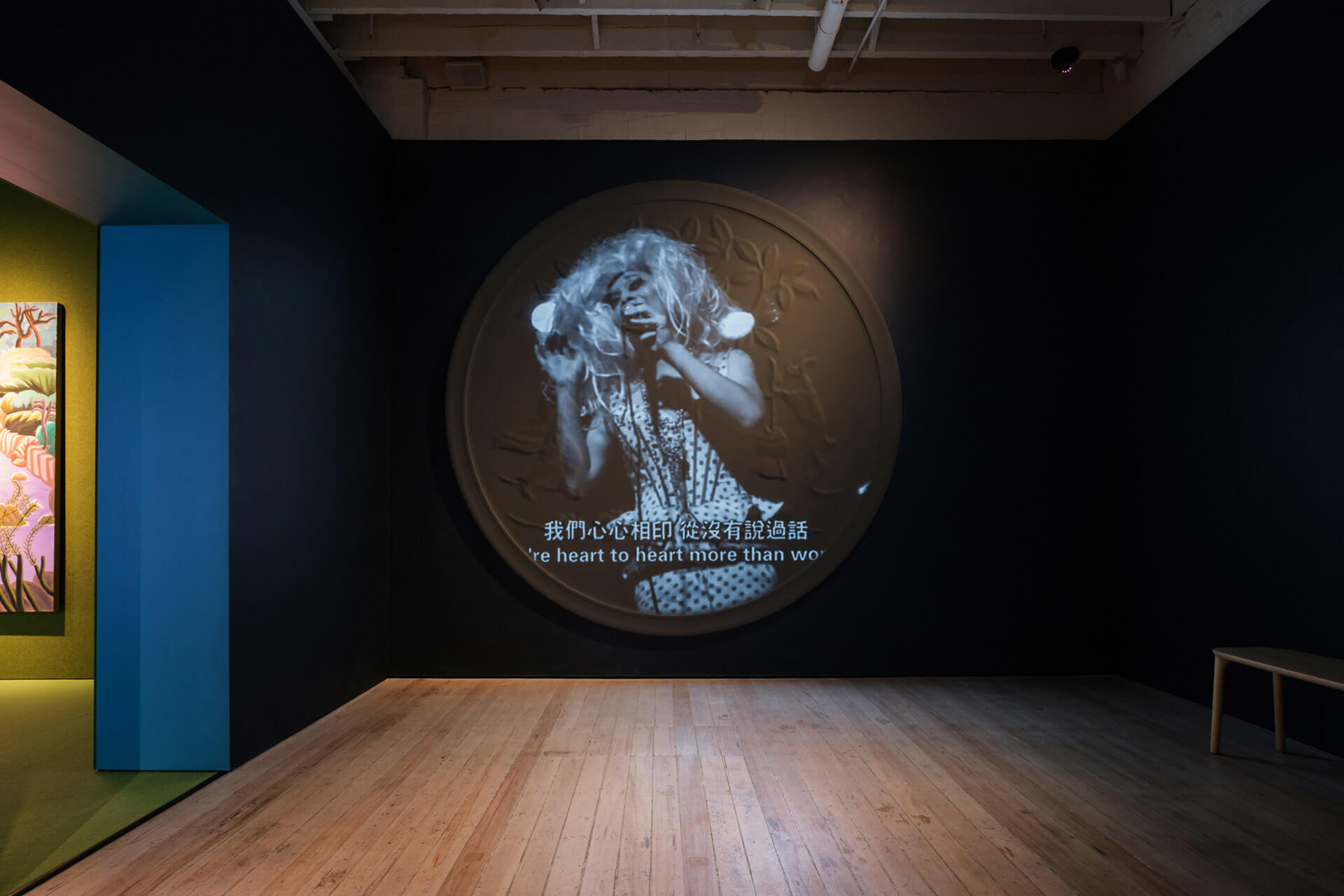 Circular video display Madame by Qiu Jiongjiong showing documentary footage with bilingual subtitles in gallery