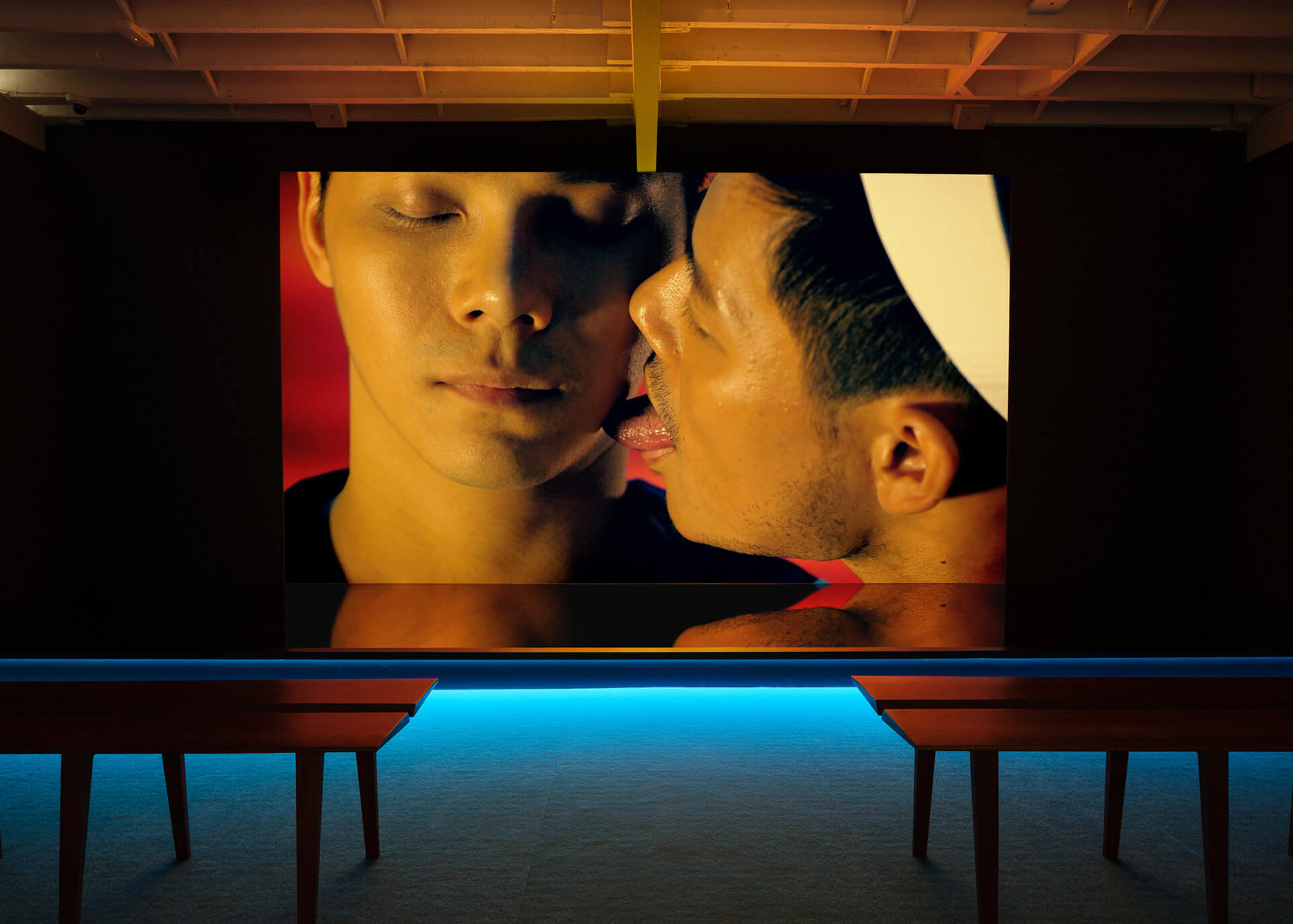 Close-up video projection by Wang Jun-Jieh showing "Passion 3" with intimate portraiture and warm lighting