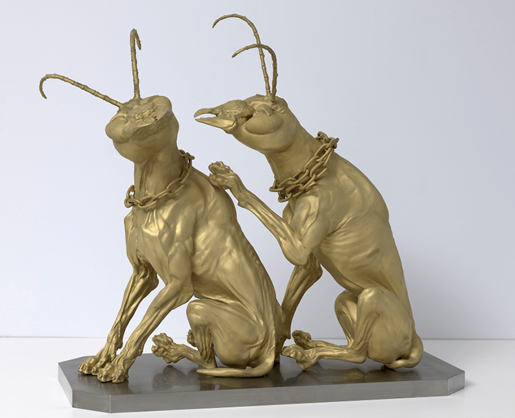 Bronze sculpture of two seated dogs with insect heads.