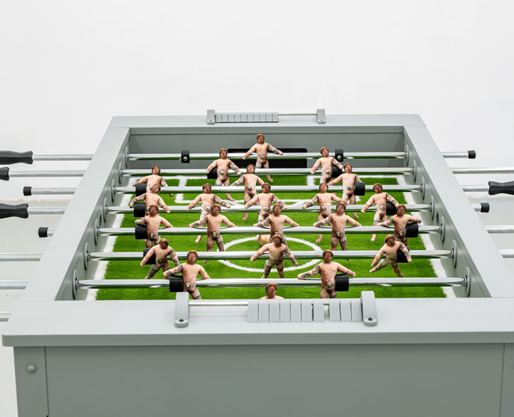 A foosball table with the figures that resemble a nude male.