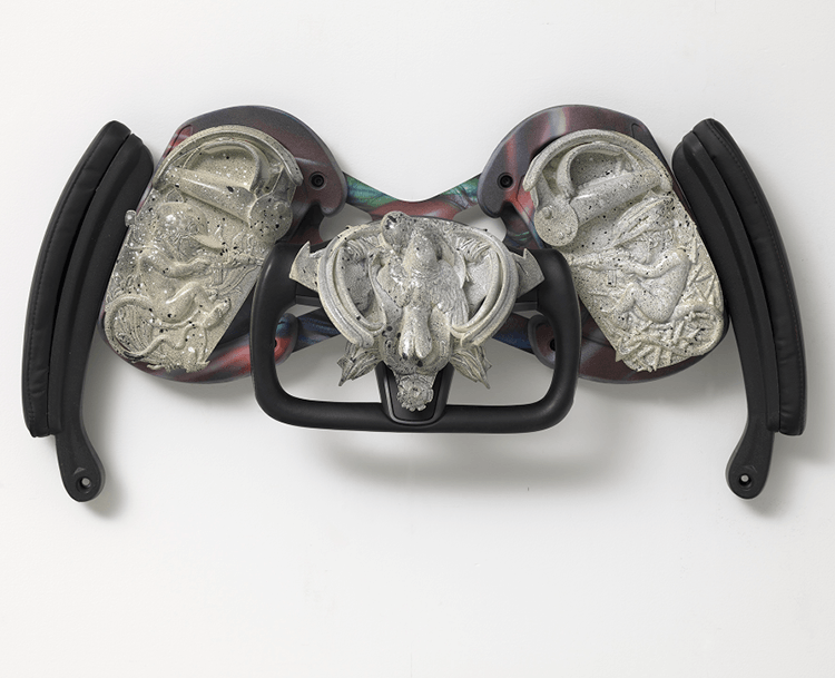 A sculpture that looks like a steering wheel and automobile parts made from a mix of materials.